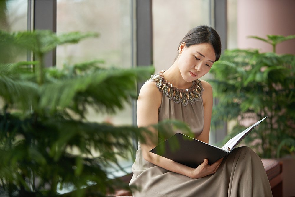 woman looking at sheet music in binder