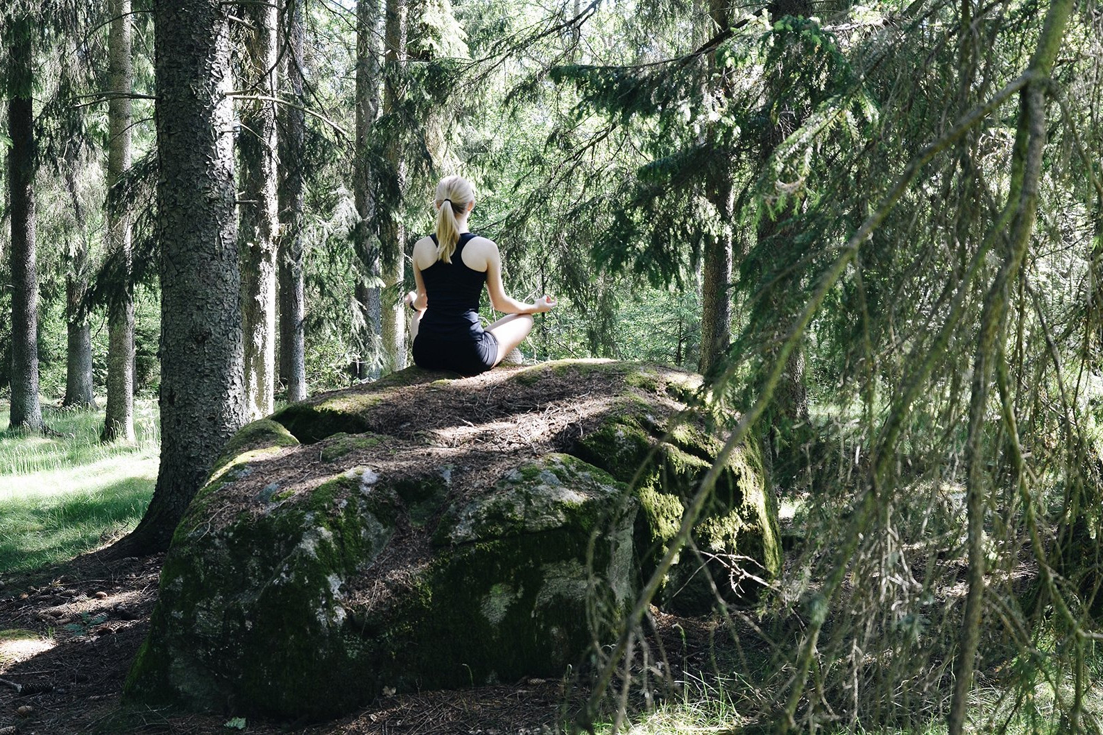 woman meditating in forest